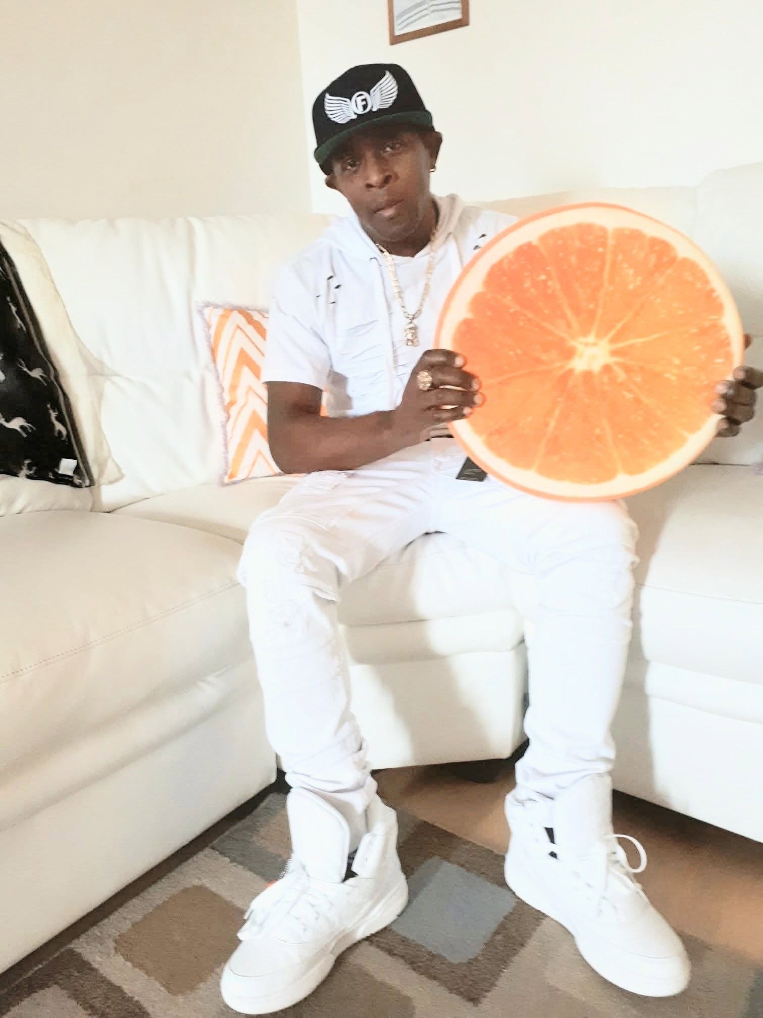 Likkle Wayne seated indoors